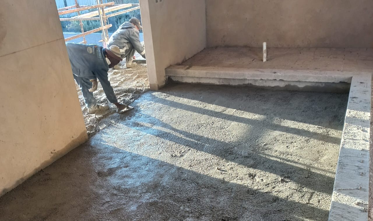 Perlite-cement insulation screed being laid on a floor before underfloor heating